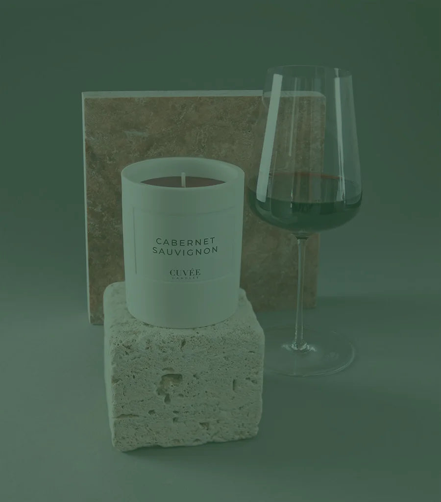 Zalto wine glass with Cabernet Sauvignon red wine and elegant Cabernet Sauvignon scented candle from CUVÉE CANDLES placed on limestone.