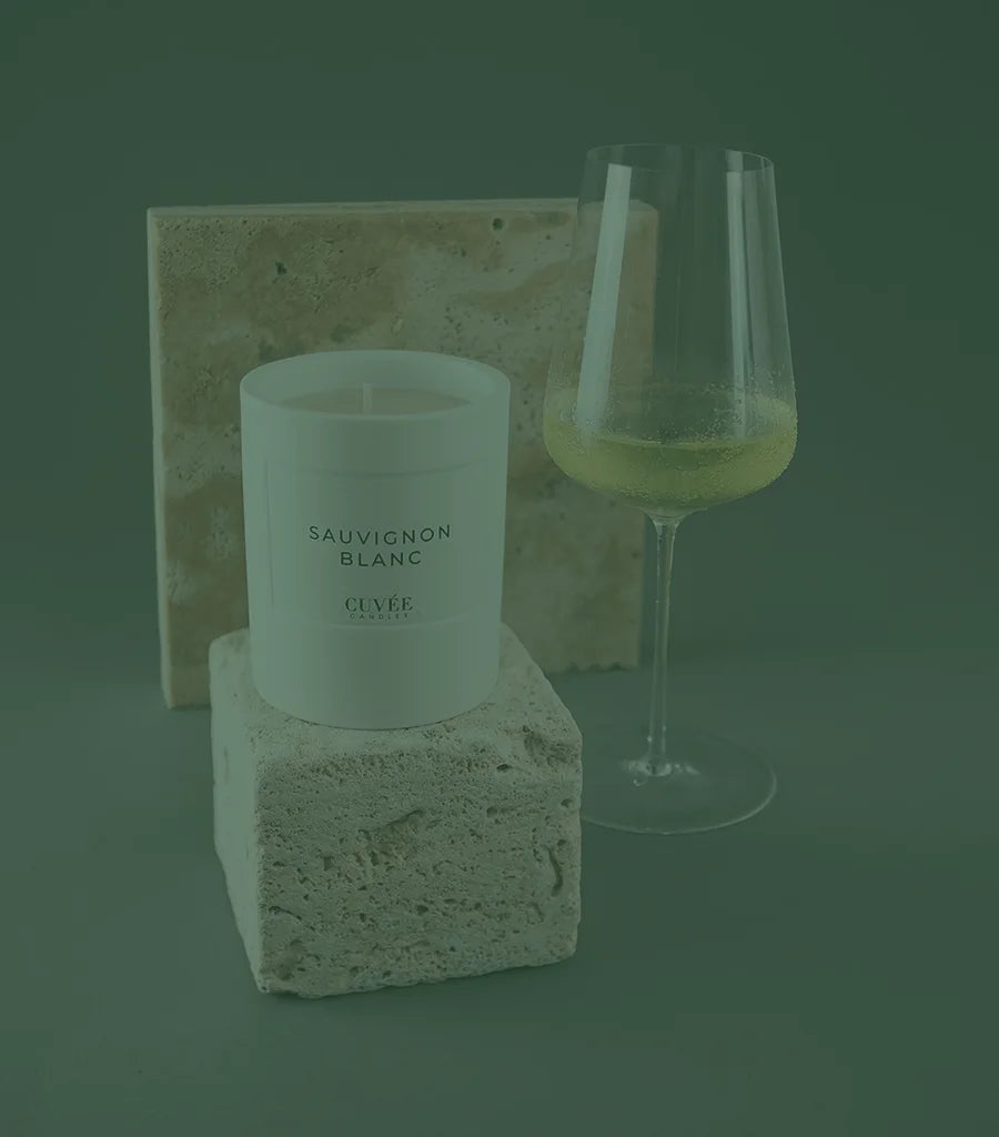 Zalto wine glass with Sauvignon Blanc white wine and elegant Sauvignon Blanc scented candle from CUVÉE CANDLES placed on limestone.